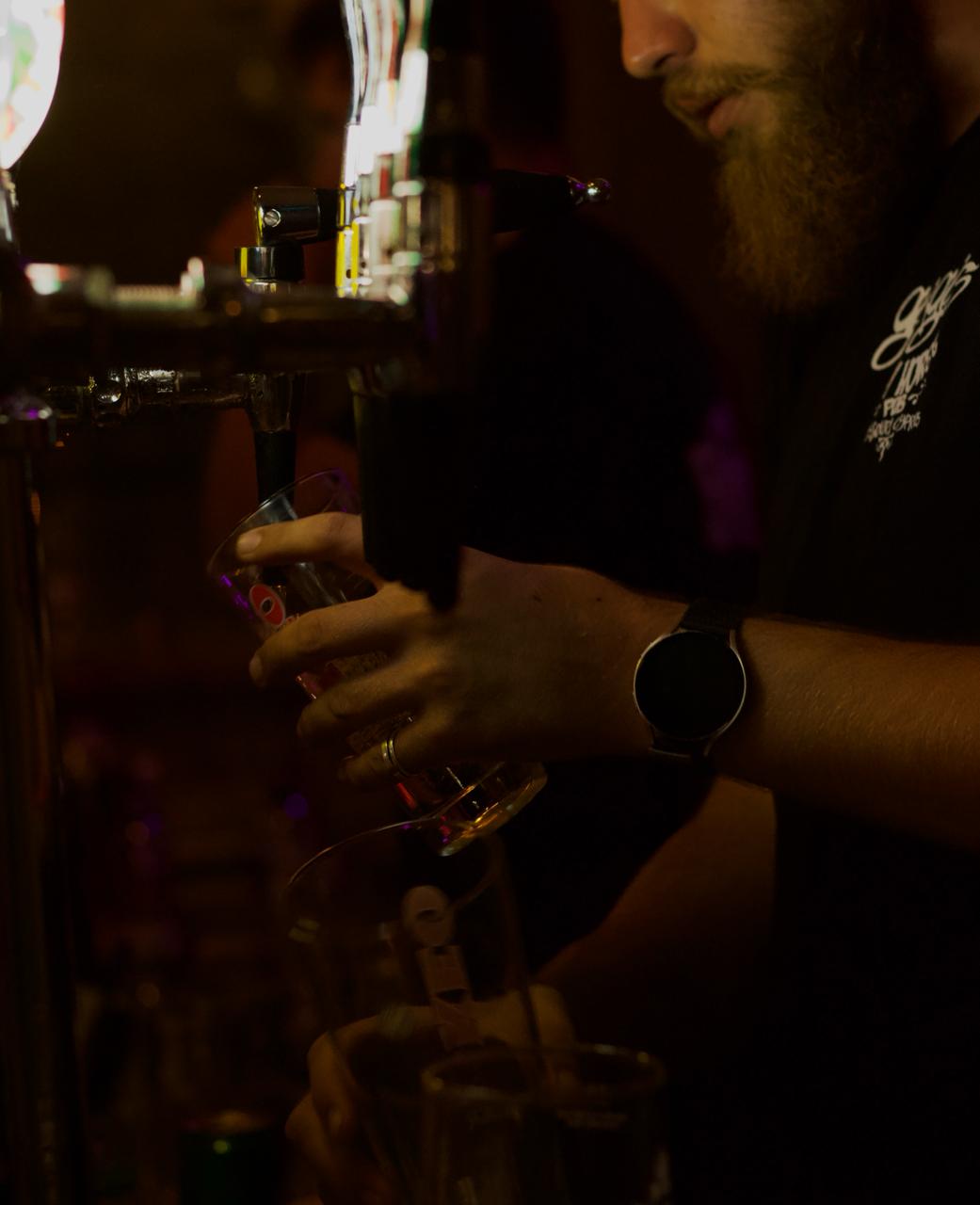 Bartender pouring drinks at the taps at George's Iron Horse Bar